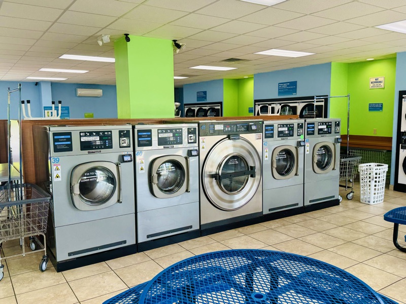 Large-capacity washers with rolling carts and laundry baskets ready to use